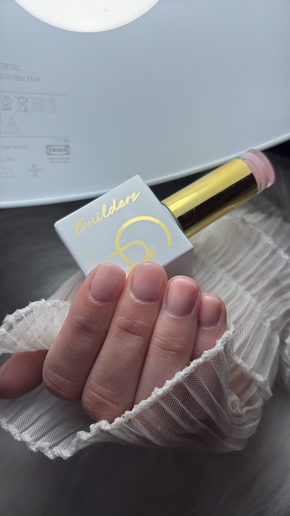 Nude nagels naast een fles builder gel