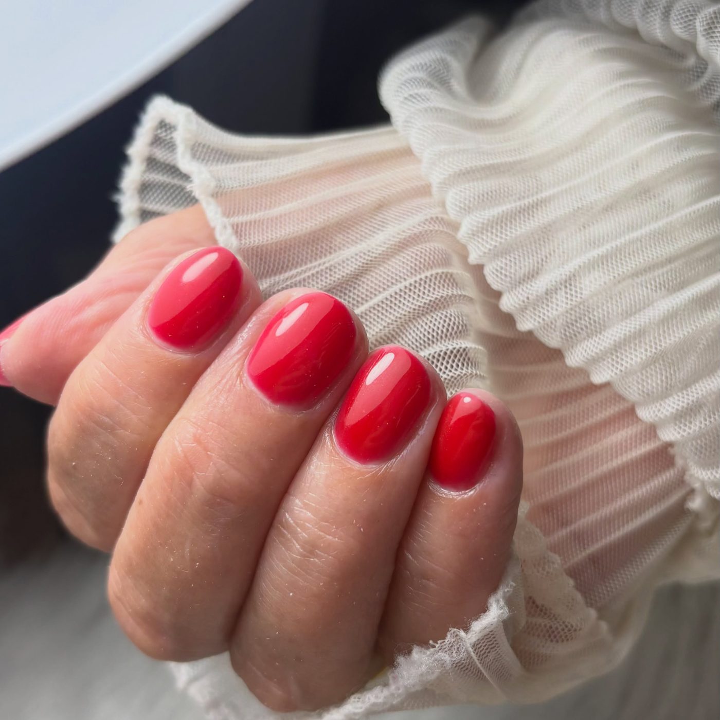 Knalrode nagels onder de witte lamp