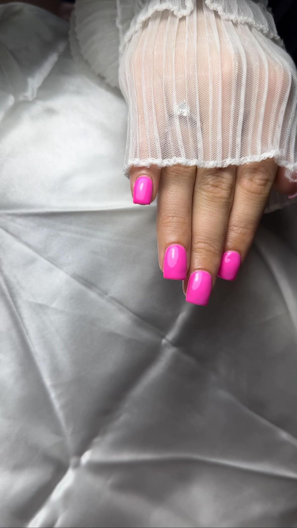 Felroze nagels op grijs satijn