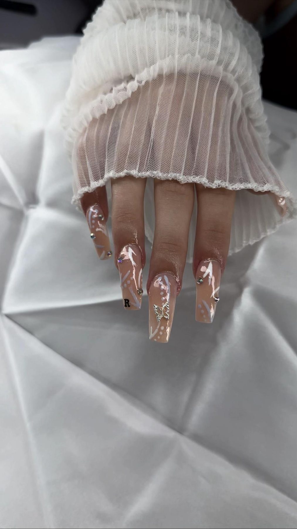 Lange nude nagels met witte nail art